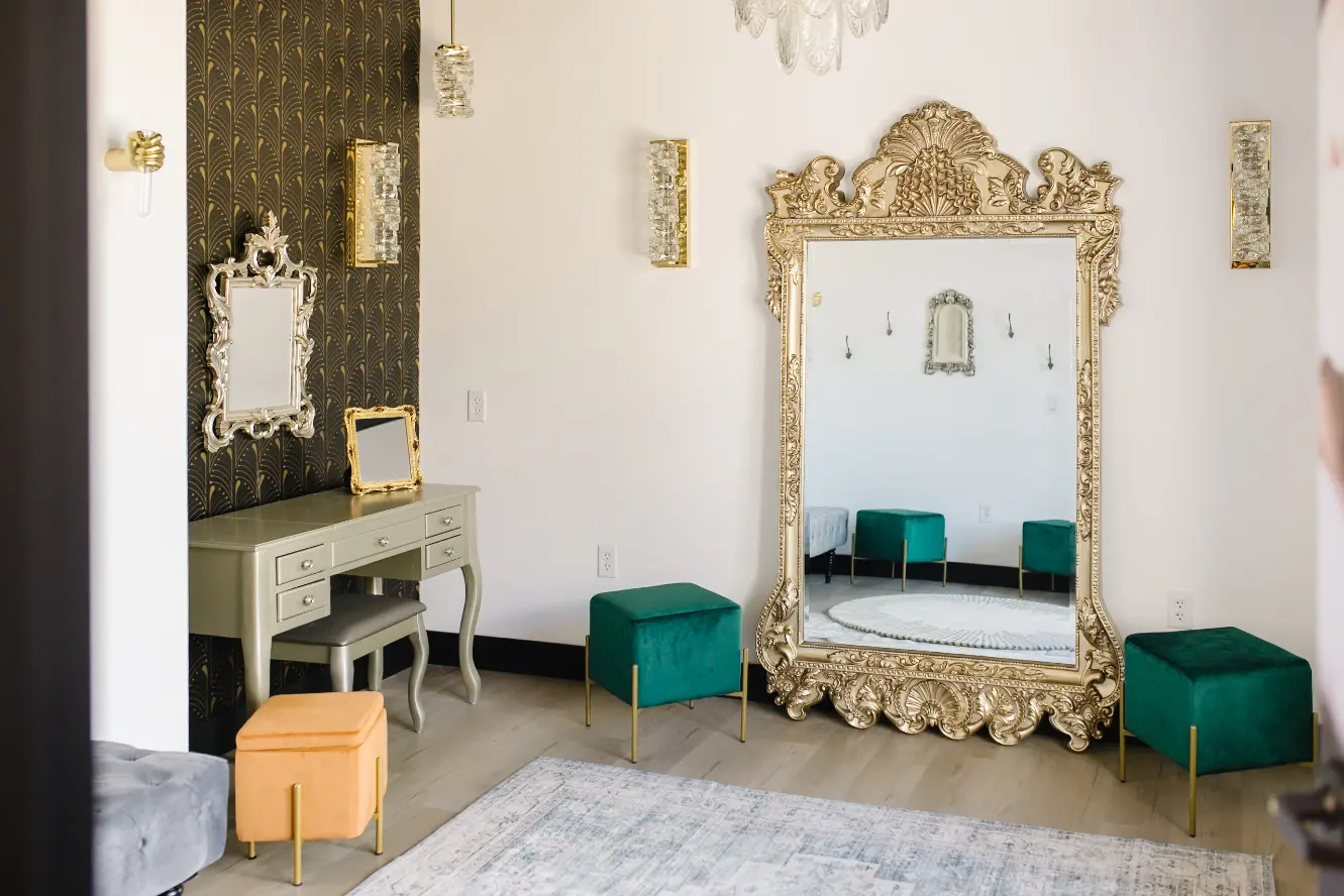 Dressing room with a large full-length, fancy mirror on the right and a small table on the left